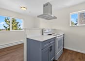 Thumbnail 14 of 42 - A kitchen with a stove top oven and a range hood.