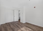 Thumbnail 17 of 42 - A room with a white door and a wooden floor.