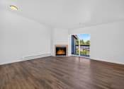 Thumbnail 6 of 42 - A room with a fireplace and a view of the outdoors through a sliding glass door.