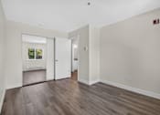 Thumbnail 41 of 42 - Bedroom at Ridgeline Apartments in Everett, WA with wood plank flooring, beige walls, and a mirrored closet door.