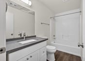Thumbnail 39 of 42 - A bathroom with a toilet, sink, and mirror.