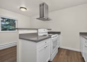 Thumbnail 28 of 42 - A kitchen with white cabinets and a stove top oven.