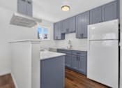 Thumbnail 11 of 42 - A kitchen with white appliances and grey cabinets.