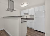 Thumbnail 29 of 42 - A newly remodeled kitchen with white cabinets and grey quartz countertops at Ridgeline Apartments