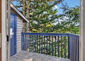Thumbnail 42 of 42 - A balcony with a blue door and a wooden railing.