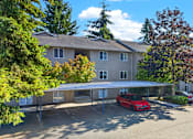 Thumbnail 2 of 42 - A red car is parked in front of a building.