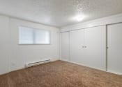 Thumbnail 19 of 36 - an empty living room with white walls and carpet and a window