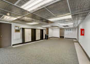 Thumbnail 29 of 36 - a large room with white walls and doors and a carpeted floor