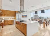 Thumbnail 26 of 26 - A modern kitchen with a large island and a view of the city.