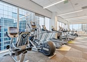 Thumbnail 21 of 26 - A gym with treadmills, exercise bikes, and elliptical machines.