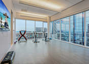 Thumbnail 22 of 26 - A gym with exercise bikes and a view of the city.