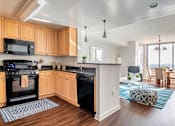 Thumbnail 3 of 25 - A kitchen with wooden cabinets and black appliances.