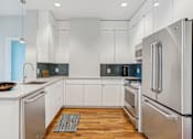 Thumbnail 3 of 26 - A modern kitchen with stainless steel appliances and white cabinets.