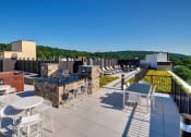 Thumbnail 9 of 26 - a rooftop patio with tables and chairs and a building in the background at Valley and Bloom, Montclair, 07042