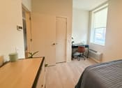 Thumbnail 14 of 20 - A room with a bed, desk, and chair.at The Jones Tower at the Collective, Pittsburgh, PA 15203