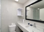 Thumbnail 18 of 22 - a bathroom with a mirror and a sink and a toilet