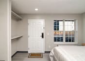 Thumbnail 11 of 22 - a bedroom with a bed and a white door and a window