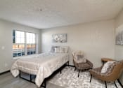 Thumbnail 14 of 22 - a bedroom with a bed and two chairs and a window