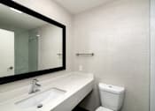 Thumbnail 19 of 22 - a bathroom with a sink and a mirror and a toilet