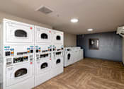 Thumbnail 20 of 22 - a laundry room with a bunch of washes and dryers