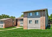 Thumbnail 23 of 25 - A row of houses with a green lawn in front.