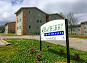 Thumbnail 19 of 25 - A sign for Bayberry Apartments stands in front of a building.
