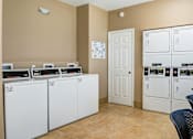 Thumbnail 15 of 25 - A laundry room with washers and dryers.