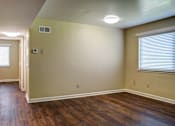 Thumbnail 4 of 25 - A room with wooden floors and a window with blinds.