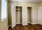 Thumbnail 9 of 25 - A room with a white door, a window with blinds, and a wooden floor.