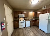 Thumbnail 6 of 17 - A kitchen with a white refrigerator, white oven, and white dishwasher.