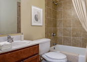 Thumbnail 10 of 25 - A bathroom with a toilet, sink, and bathtub.