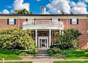Thumbnail 10 of 15 - A red brick building with a white front porch and a sign that reads "PH400".