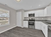 Thumbnail 6 of 40 - modern kitchen with window and white cabinets along with stainless steel appliances