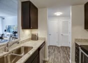 Thumbnail 30 of 46 - Kitchen with granite counter tops and a sink at Gramercy on Garfield, 45202