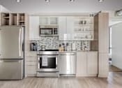 Thumbnail 16 of 49 - A modern kitchen with a refrigerator, oven, and microwave.at Sky Central, Cincinnati Ohio