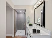 Thumbnail 20 of 54 - a white bathroom with a large mirror and a shower at Indian Creek Apartments, Cincinnati, OH