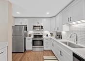 Thumbnail 21 of 54 - a white kitchen with stainless steel appliances and white cabinets at Indian Creek Apartments*, Cincinnati, OH