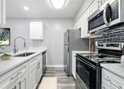 Thumbnail 3 of 18 - A modern kitchen with white cabinets and stainless steel appliances.at Hanna Village, Indianapolis, IN