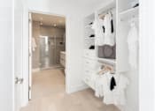 Thumbnail 22 of 49 - A white closet with clothes hanging and a bathroom in the background.at Sky Central, Cincinnati, OH