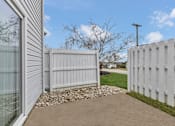 Thumbnail 23 of 40 - A white fence and a grey concrete pathway in front of a house.