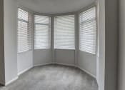 Thumbnail 35 of 46 - Empty room with three windows and a carpeted floor at Gramercy on Garfield, Cincinnati, OH