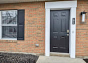 Thumbnail 31 of 40 - A black door with a white frame is on a brick house.