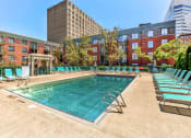 Thumbnail 43 of 46 - Swimming pool with chairs and a building in the background at Gramercy on Garfield, Cincinnati, OH