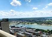 Thumbnail 43 of 49 - A cityscape with a river and a bridge in the distance at Sky Central, Cincinnati, OH