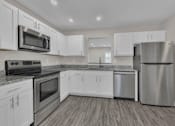 Thumbnail 4 of 40 - A modern kitchen with stainless steel appliances and white cabinets.