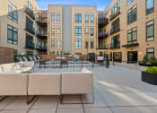 Thumbnail 71 of 81 - an outdoor patio with couches and chairs in front of an apartment building at Four23/Hoge, Cincinnati
