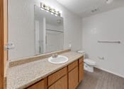 Thumbnail 5 of 27 - A bathroom with a sink, mirror, toilet and a shower.