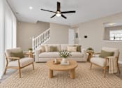 Thumbnail 9 of 40 - A living room with a white couch, two chairs, and a coffee table.