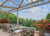 Thumbnail 30 of 64 - A patio with white furniture and a view of the city.