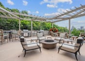 Thumbnail 28 of 64 - A patio with a fire pit and chairs.